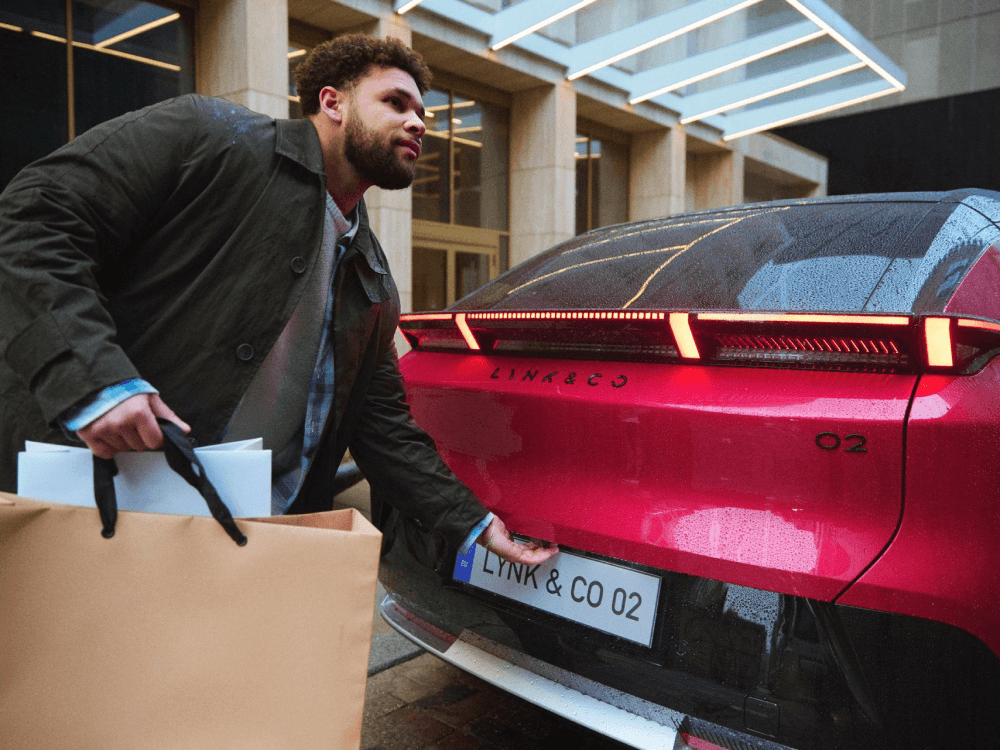 Man loading the trunk of the red 02