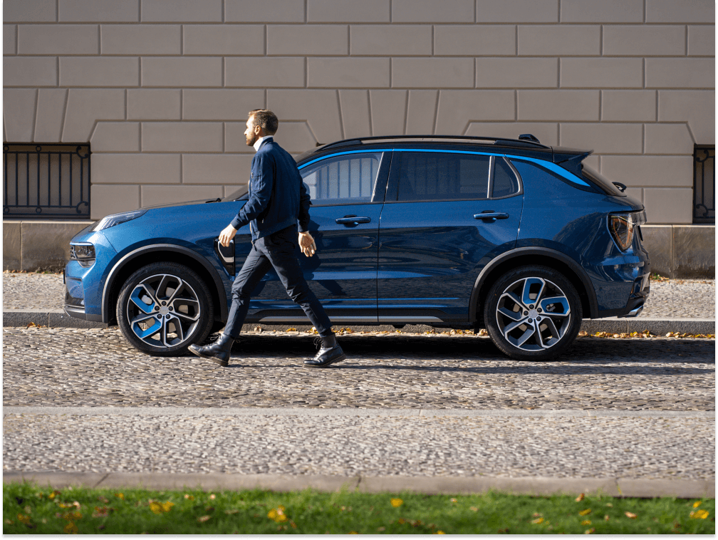 A man walking beside a blue Lynk & Co 01